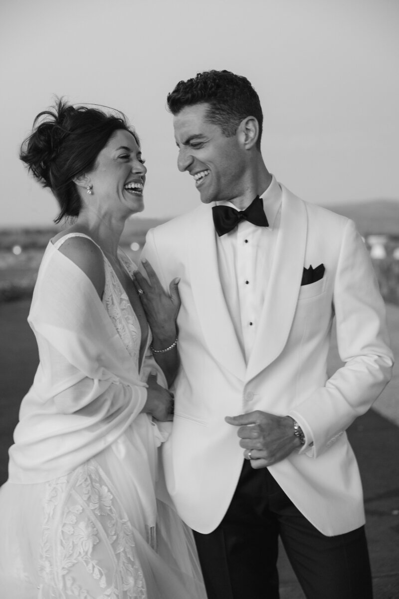 Black and white photo of bride and groom walking during newlywed sunset photos in Napa California