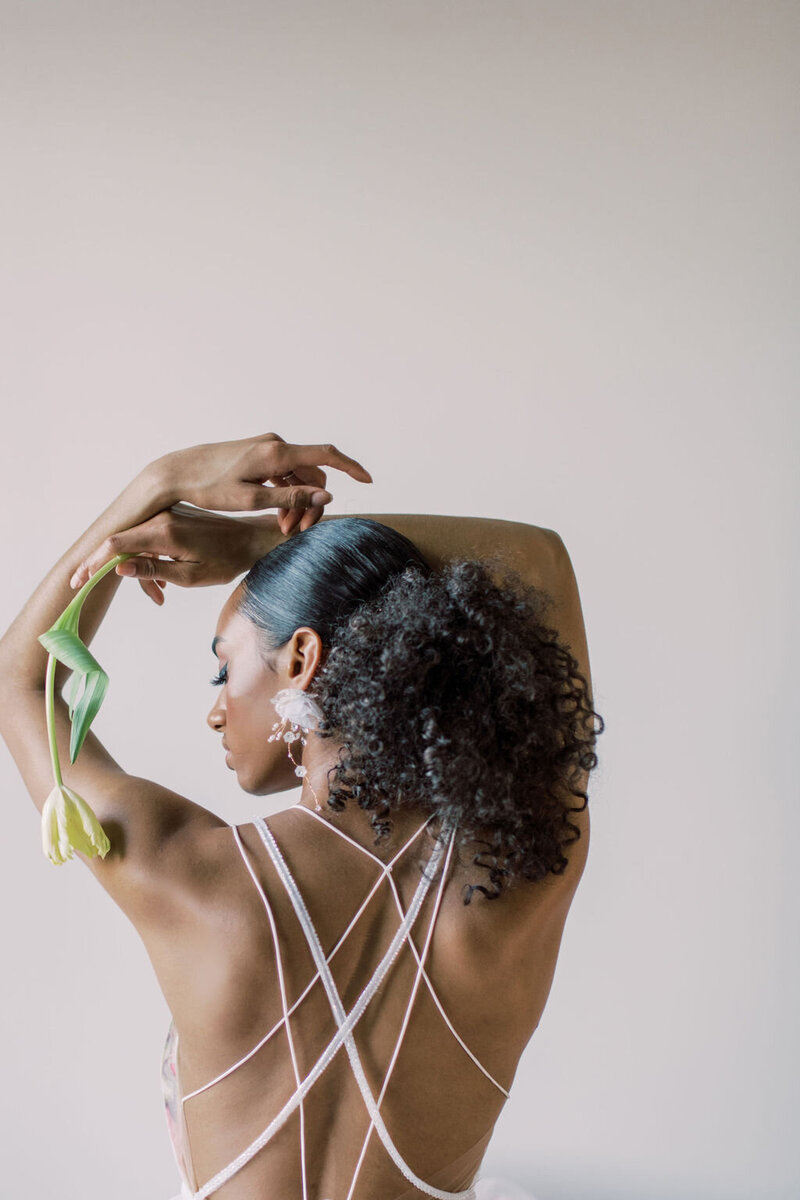 Artistic portrait of a woman in a strappy white wedding dress captured in a minimal, editorial style