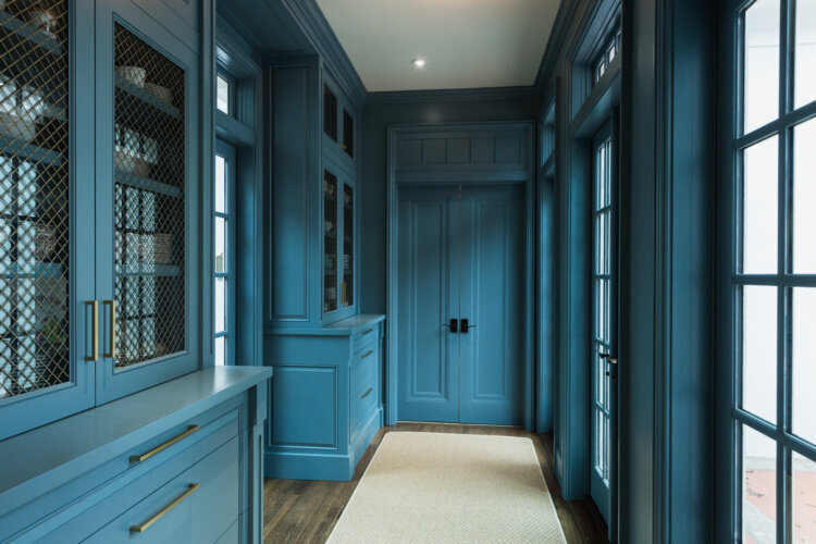 Image of grand hallway with painted blue cabinets and doors