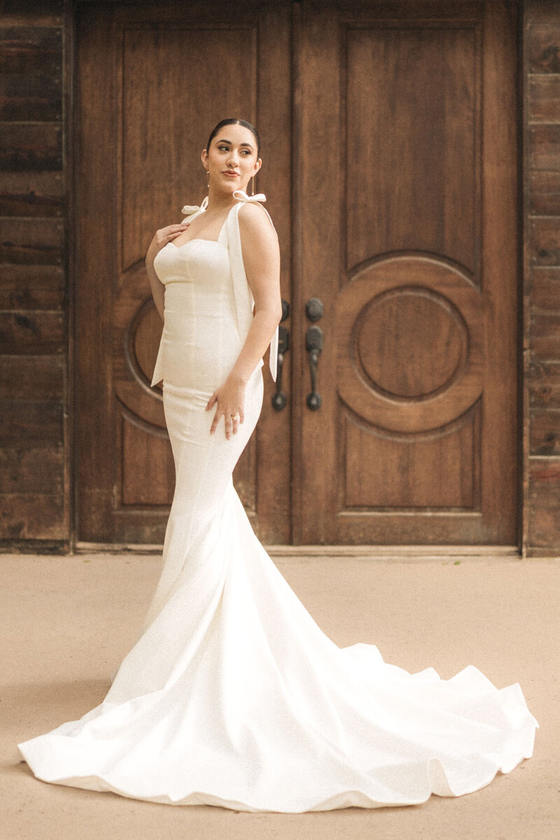 Bride in a mermaid dress by barn doors looking elegant prior to her wedding day ceremony in Miami, FL.