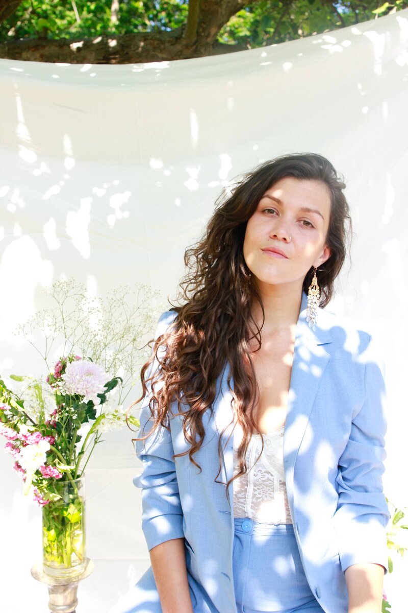 dark-haired woman wearing a blue blazer looking to the camera