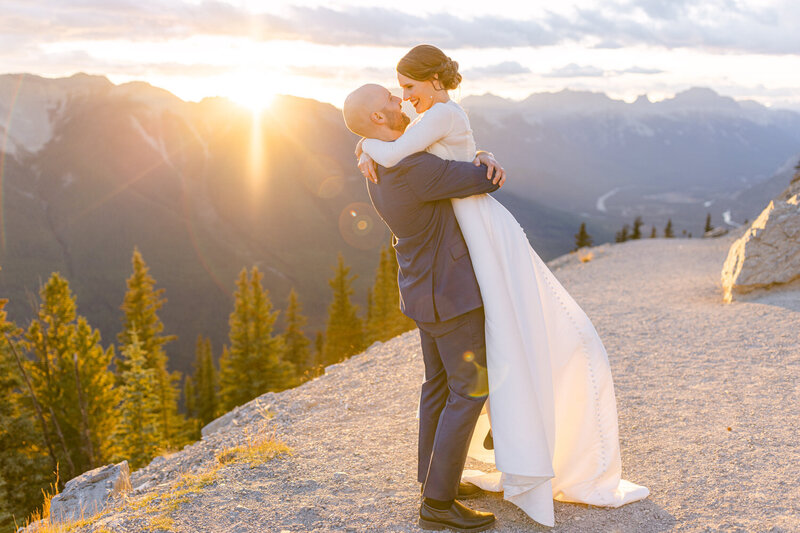 A fun sunset moment as the bride and groom take a break outside the Sky Bistro Banff Gondola during their wedding day reception.