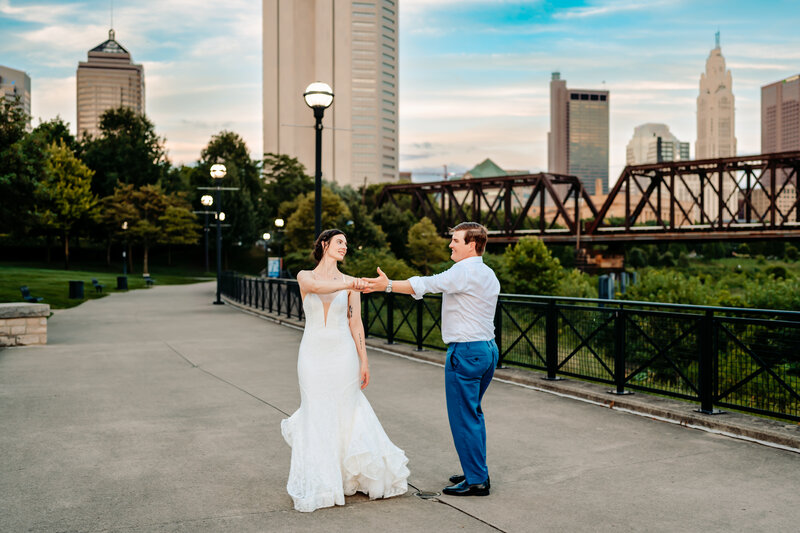 Wedding bride and groom dancing together in front of columbus city skyline on their wedding day