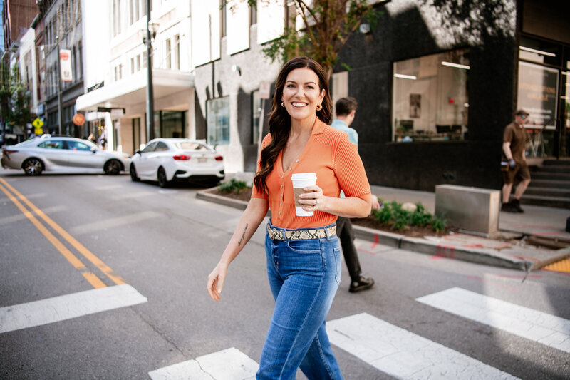 Online marketing expert - Amy Porterfield Headshot walking with coffee