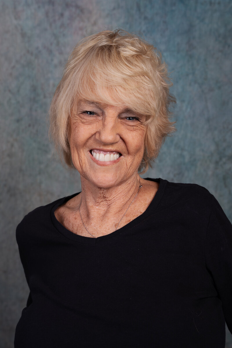 a photo of an elder woman smiling in a photo studio