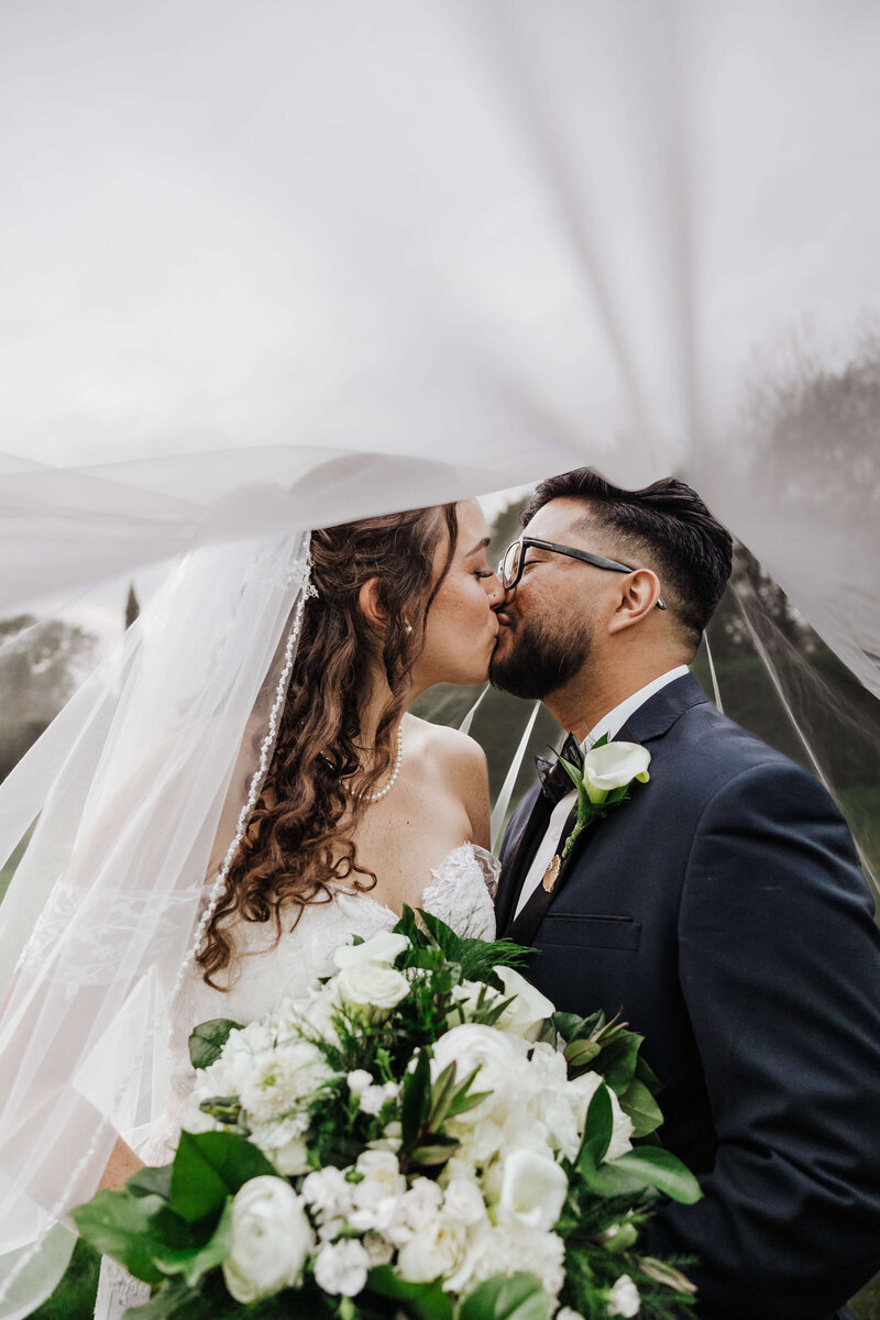Orlando wedding photography portrait of a bride and groom kissing beneath the veil.