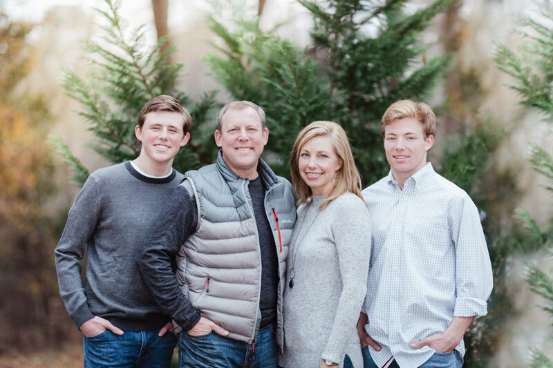 Peachtree City family posing in front of trees during their family portrait session.