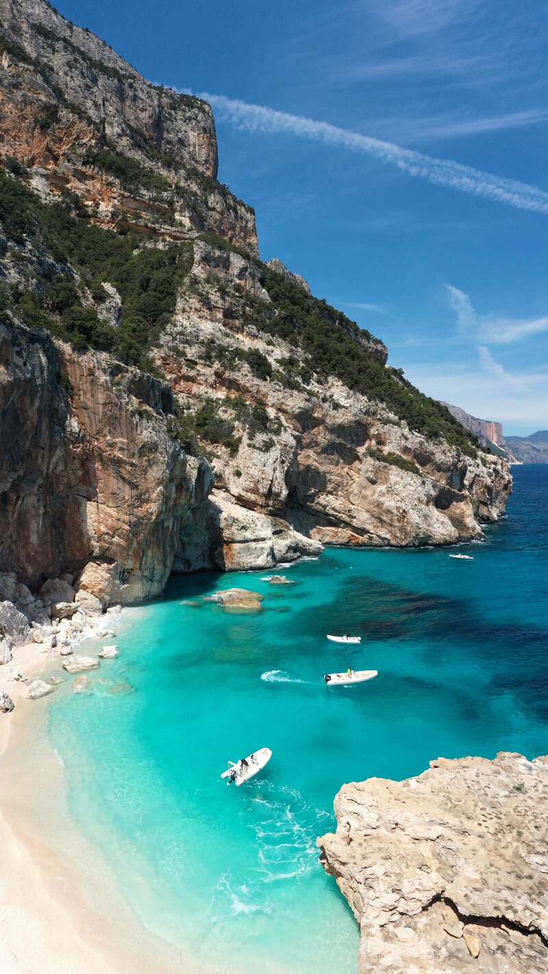 boats in turquoise water in Sardinia