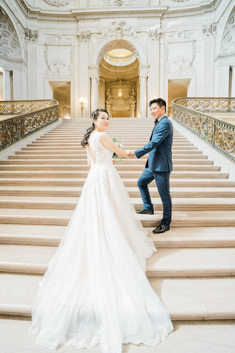 husband and wife pose for portraits after san francisco city hall wedding