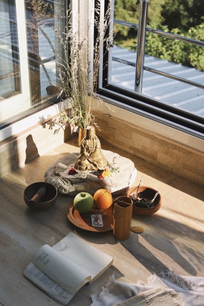 Yoga altar with a buddha, sound bowl, notebook and fruits