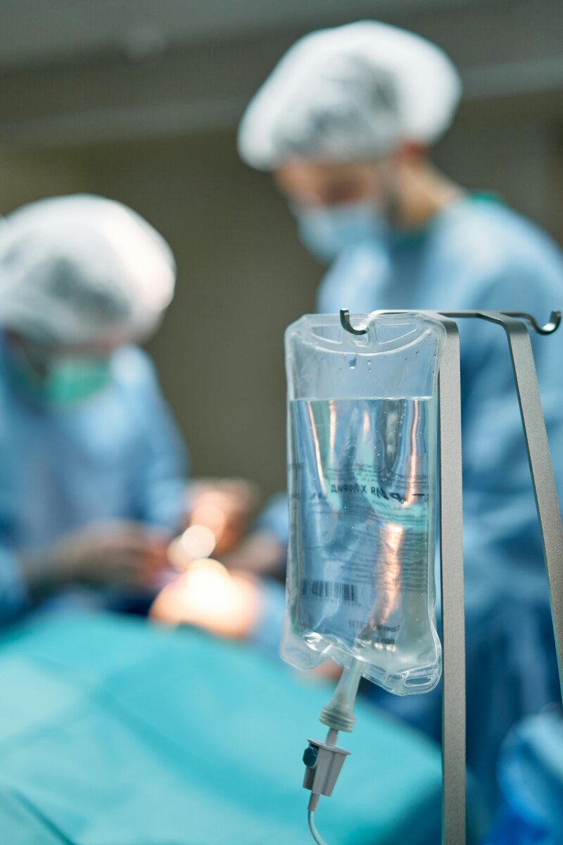 iv drip bag with surgeon in background