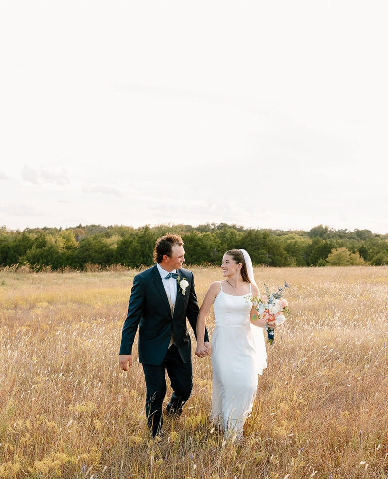 New married couple looking at each other while walking outdoors