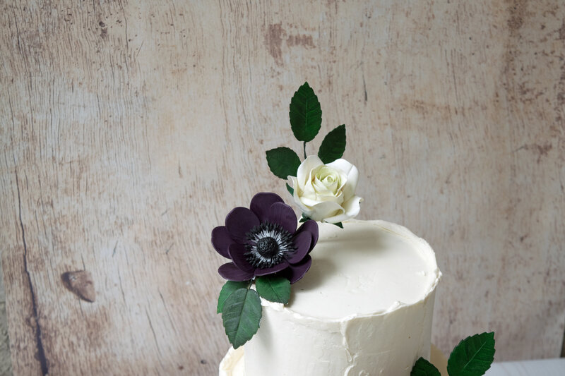 dark purple anemone sugar flower on buttercream cake