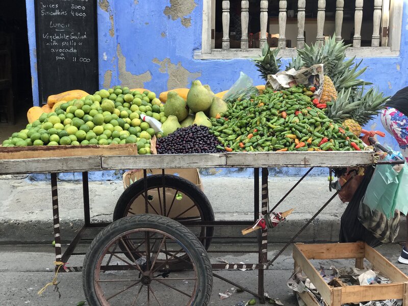 Outdoor produce market cart with vibrant tropical fruits and vegetables