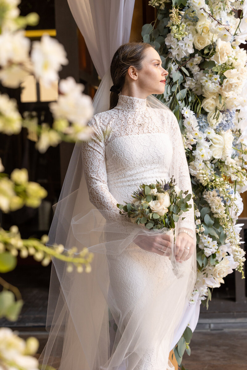 A bride and groom holding hands and walking along the water