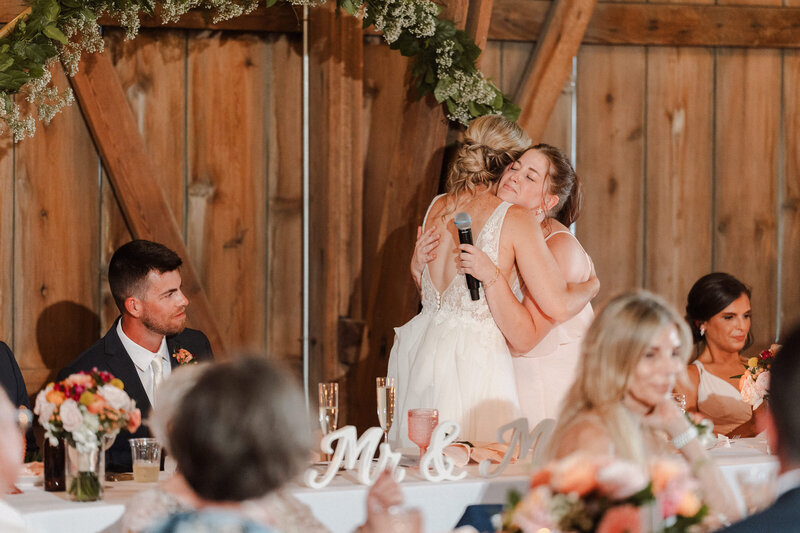 Maid of honor hugs her bride after sharing wedding toast