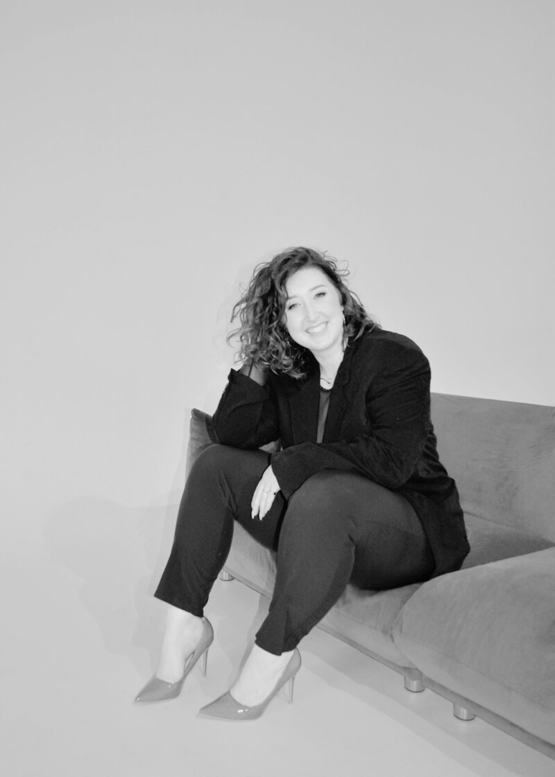 Image of Erin sitting on a couch in heels.