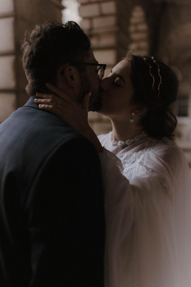 Editorial couples portrait in warm window light at a historic Scottish venue, captured in a cinematic fine art style by wedding photographer Aly Robinson.