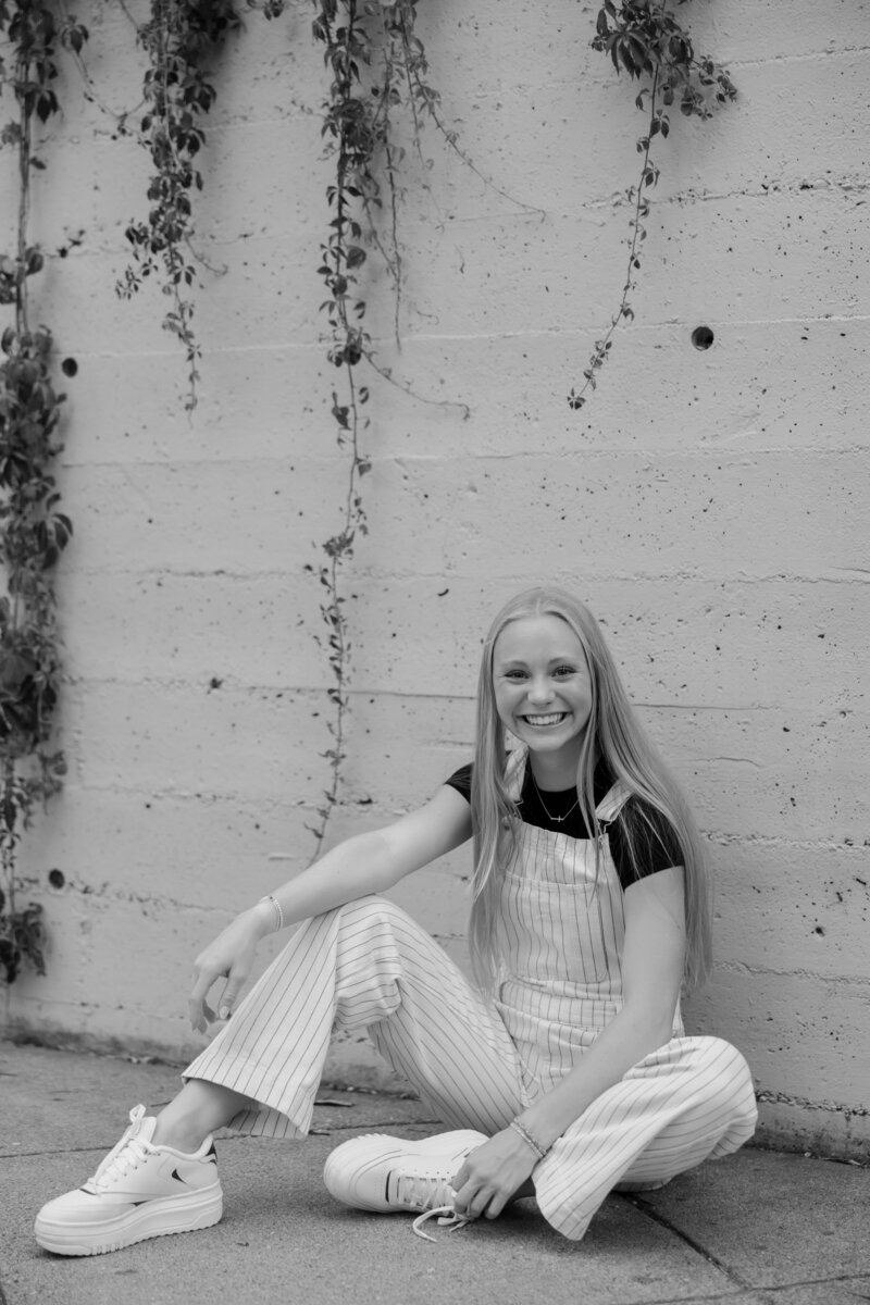 girl sitting in front of garage doors arm on leg