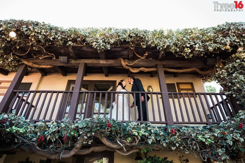 Bride and Groom talk to each other on the balcony at The Hacienda restaurant