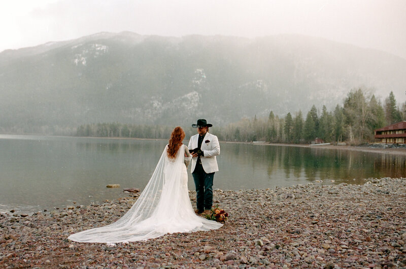bride and groom exchanging vows next to a lake in glacier national park