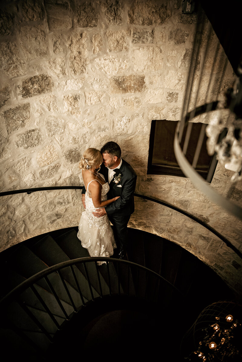 Wedding couple in Bryan TX kissing on stairs