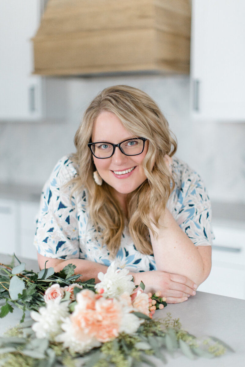 photographer Kellie Hetler smiles at camera in kitchen