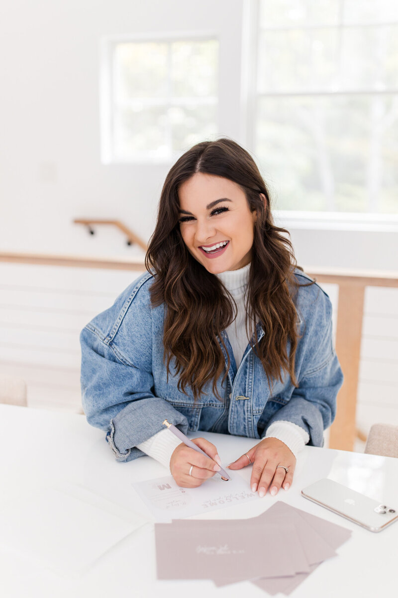 Maine photographer sitting at desk smiling