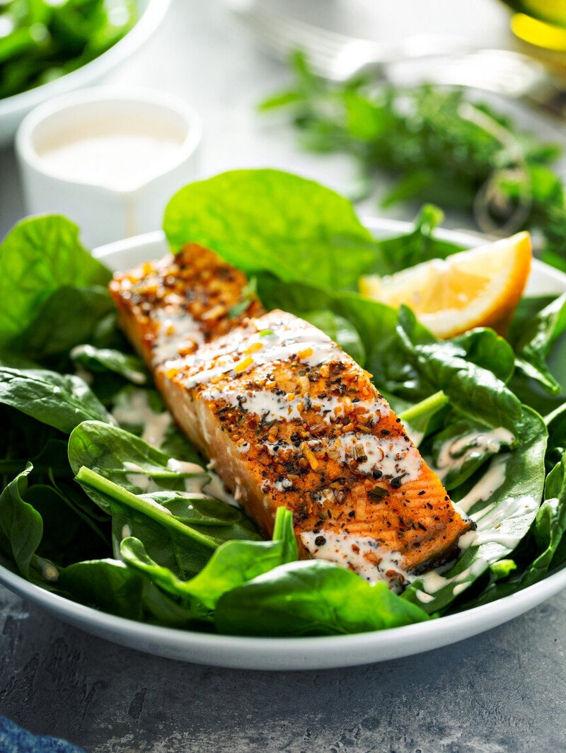 Protein-rich salmon and baby leaf spinach meal with creamy lemon dressing to support weight and hormone balance in perimenopause