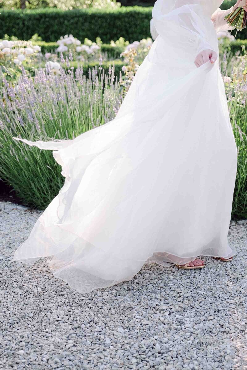 Bride's wedding dress blows in the breeze at Monet Vineyards garden Seattle Wedding Venue