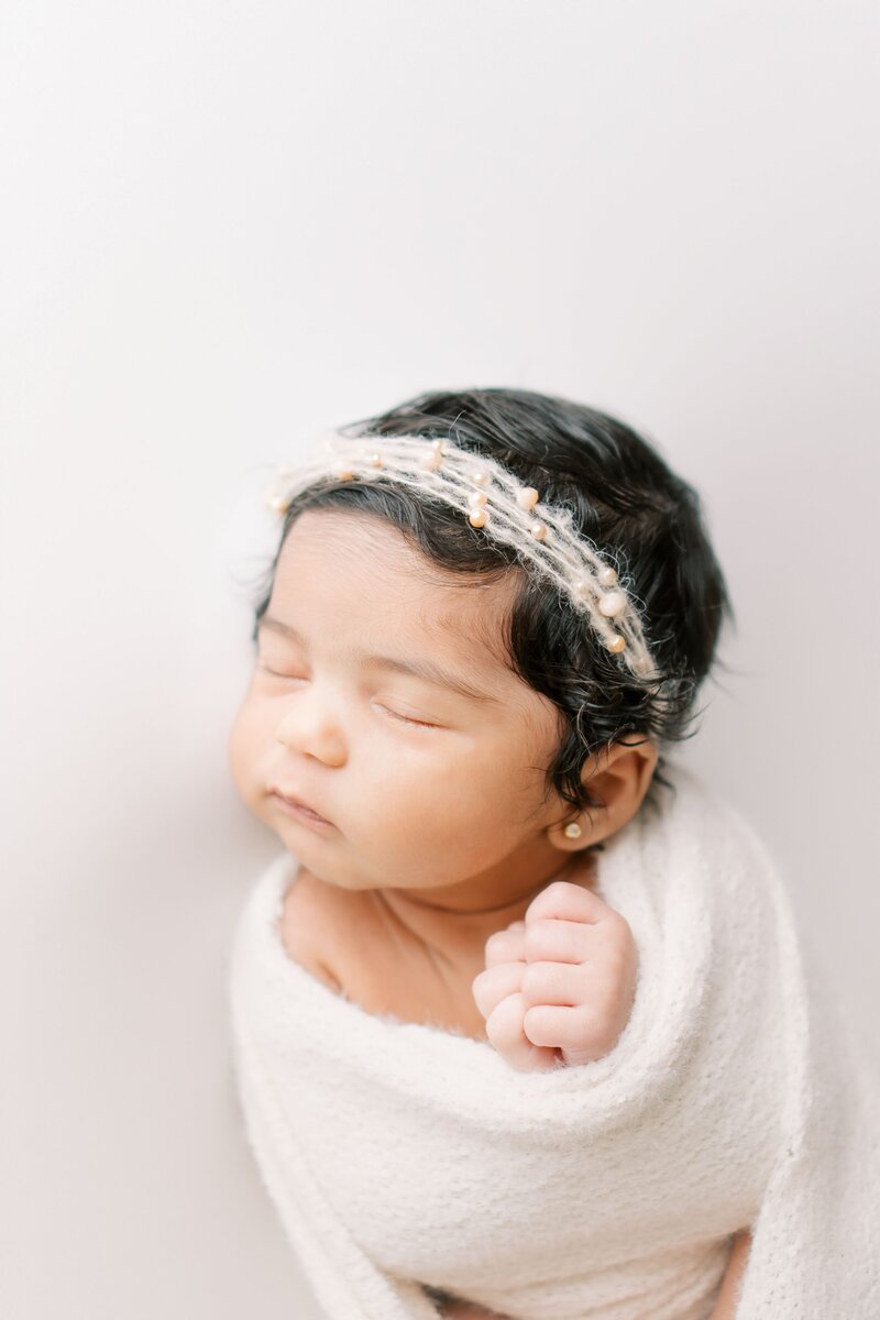 baby girl sleeping with white wrap for newborn photos in DFW