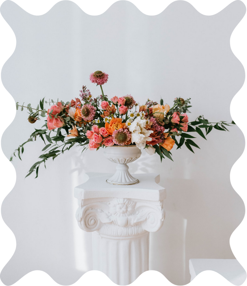 Whimsical wedding floral design arrangement with a wavy border around the image