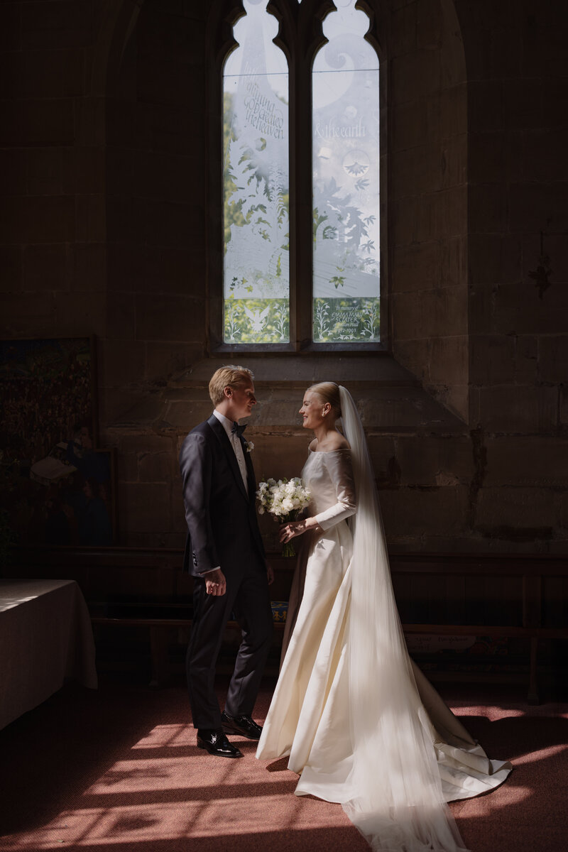 A portrait of Edward and Kristina walking arm in arm at the stunning front gardens of Hedsor House in the cotswolds