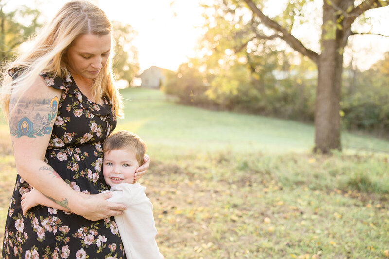 Little boy giving his mom hugs while smiling at the camera and mom looks lovingly down at him at Phillips Park in Beavercreek, Ohio.