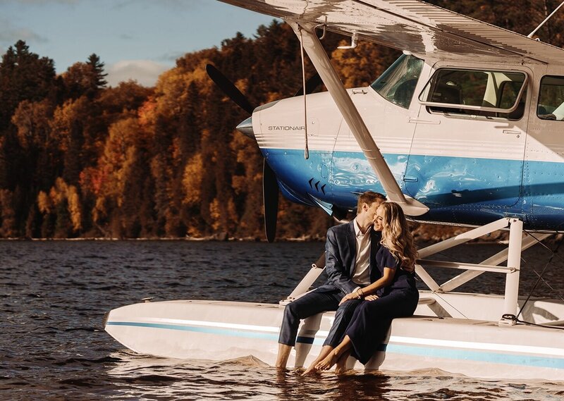 Couple seated on the edge of a seaplane.