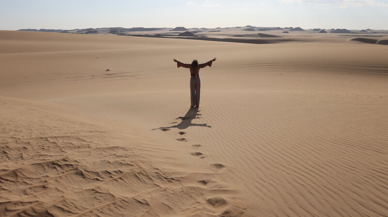 Solo female traveler exploring a Moroccan palace with arched architecture.