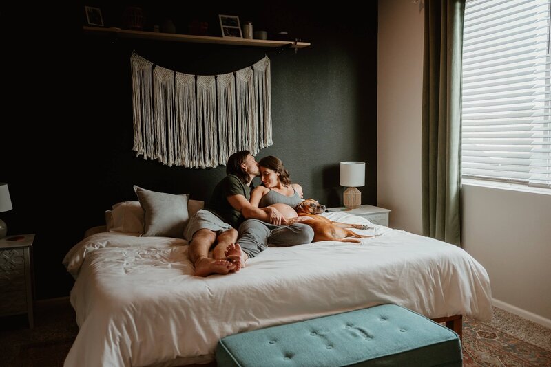 Expecting Couple Relaxing on Bed With Dog