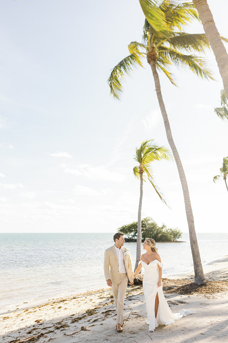 A beautiful wedding couple walking hand-in-hand at The Breakers in Miami, Florida, captured by Claudia Amalia Photography, a wedding and lifestyle photographer based in Miami and Florida Keys South Florida, specializing in destination weddings.