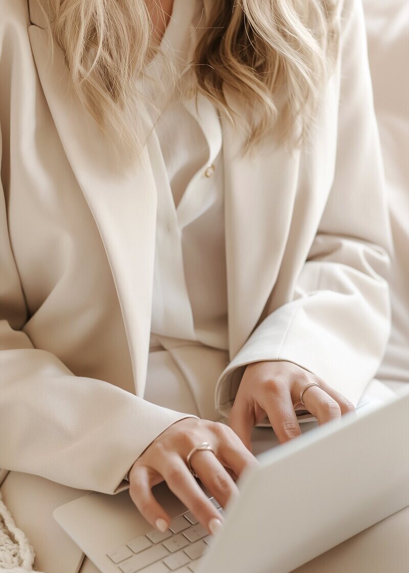 Woman typing on the computer while taking a bridal makeup course.