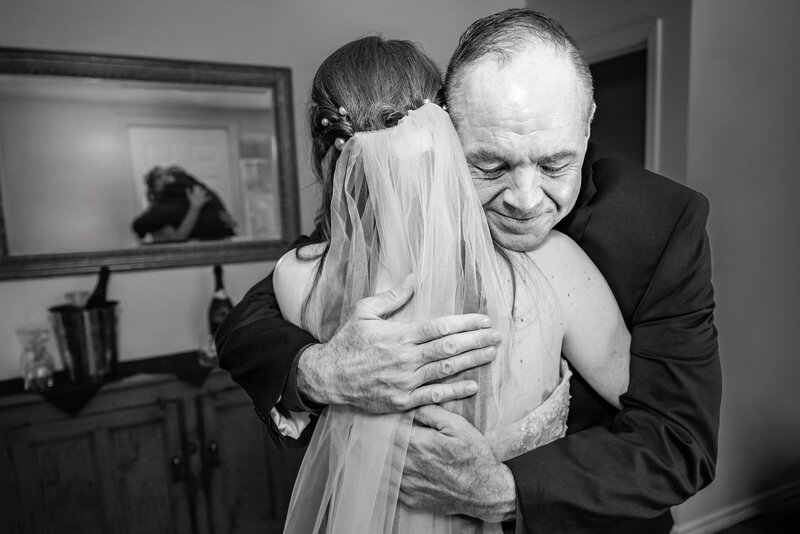 Father hugs his daughter tightly after seeing her in her dress for the first time.