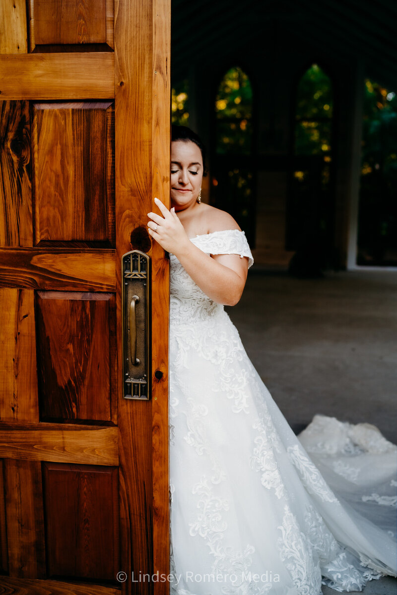 photo of bride with antique door in off shoulder dress at Cypress Grove in Eunice, Louisiana