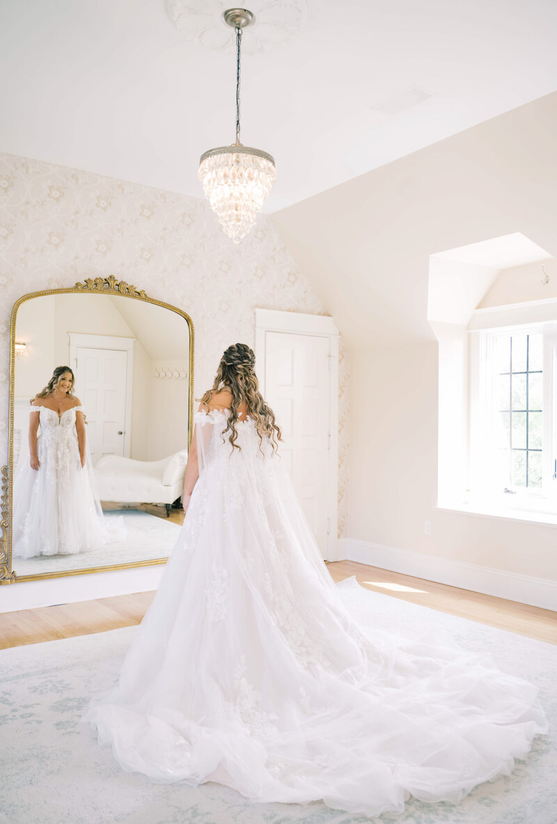 A bride looking in the mirror at Venue3Two captured by her Grand Rapids wedding photographer