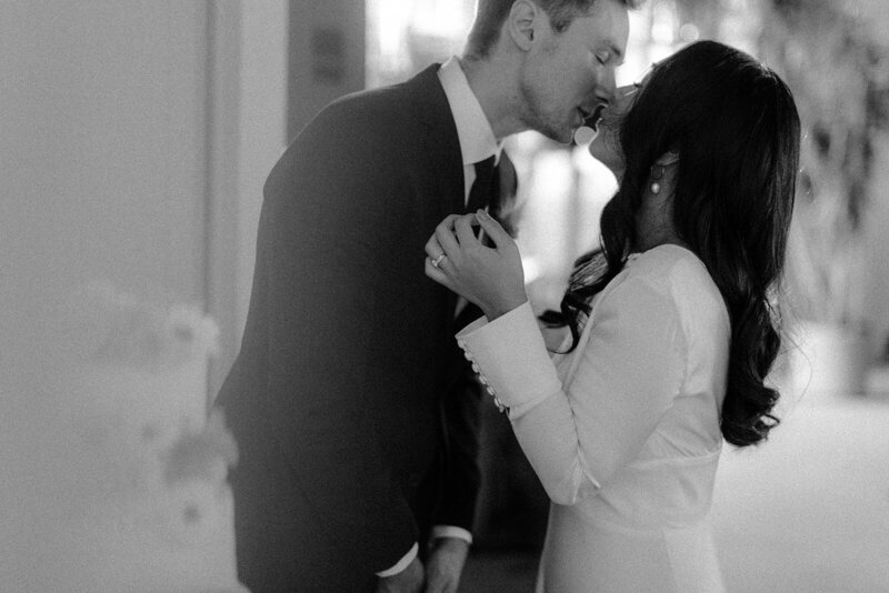 Bride and Groom sharing a kiss after cutting their wedding cake at Each Other in Minneapolis