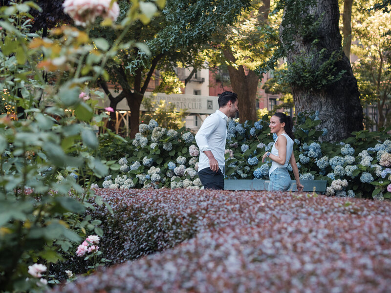 Attractive young couple enjoying their walk at the Gramercy Park South amonth the blue hydrangeas.