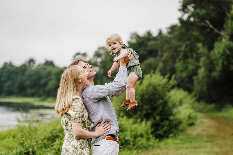 parents lift toddler into air during first birthday photos