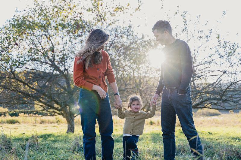 A family playing together outdoors at sunset, photographed by Connecticut family photographer Rebecca Bloomfield using a relaxed, documentary approach that captures genuine connection.