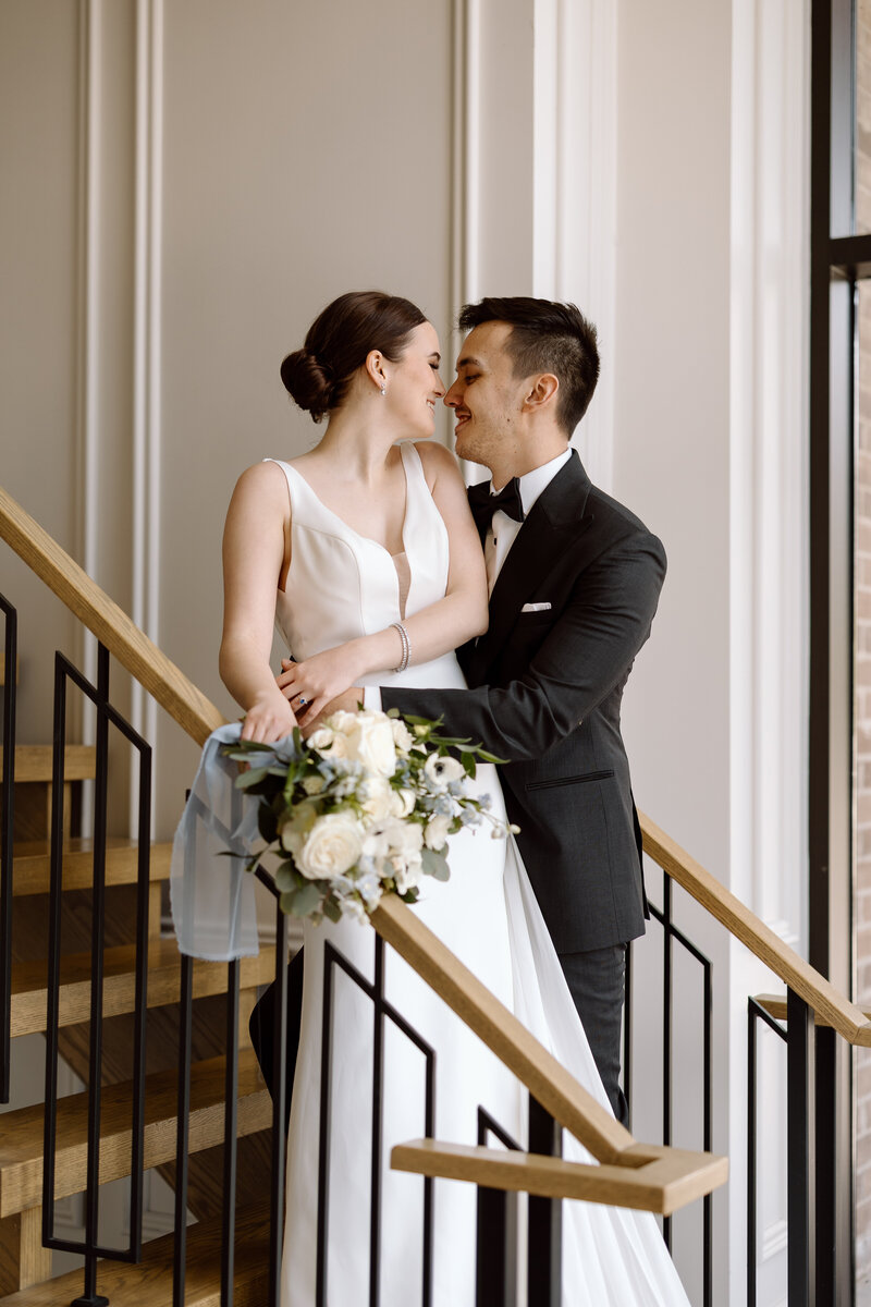 A couple embracing in a kiss on the stairs at Arlington Estate event centre in Toronto.
