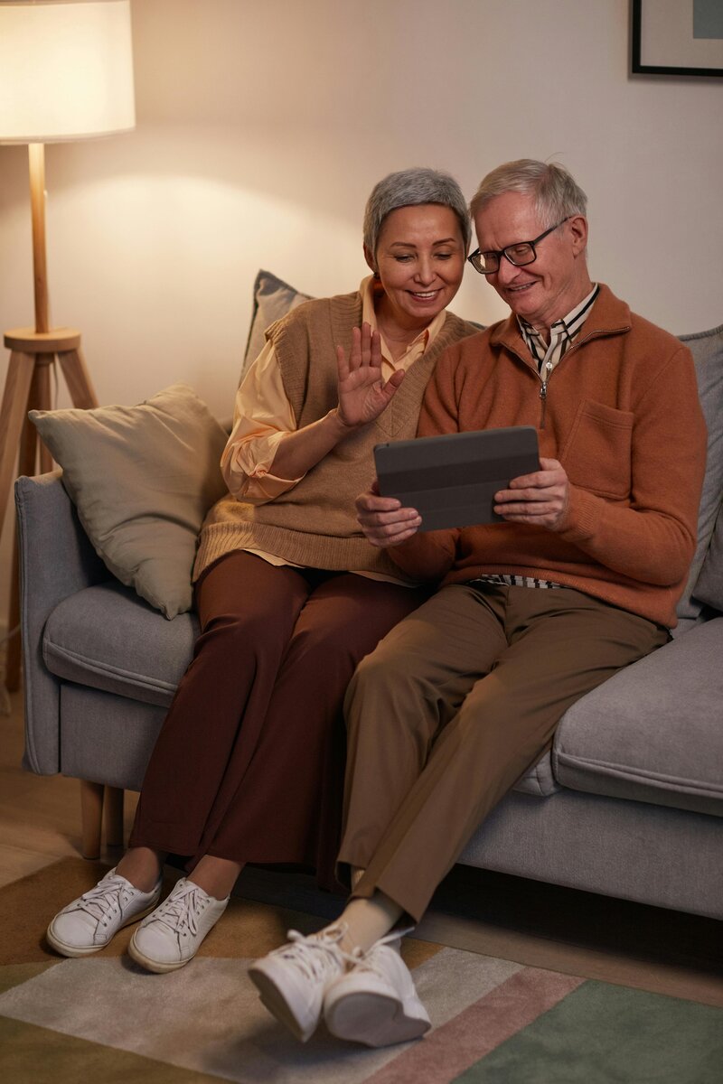 older couple on ipad on a video call waving