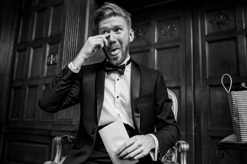 Groom tearing up from reading letter his fiance wrote him at a wedding party. 