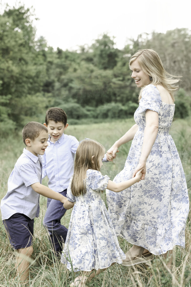 mother playing with her children in a field